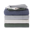 Stack of folded bed sheets in various colors on a white background