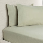 Light green bedding set on a bed with a neutral background