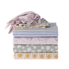 Stack of folded fabric with various patterns on a white background