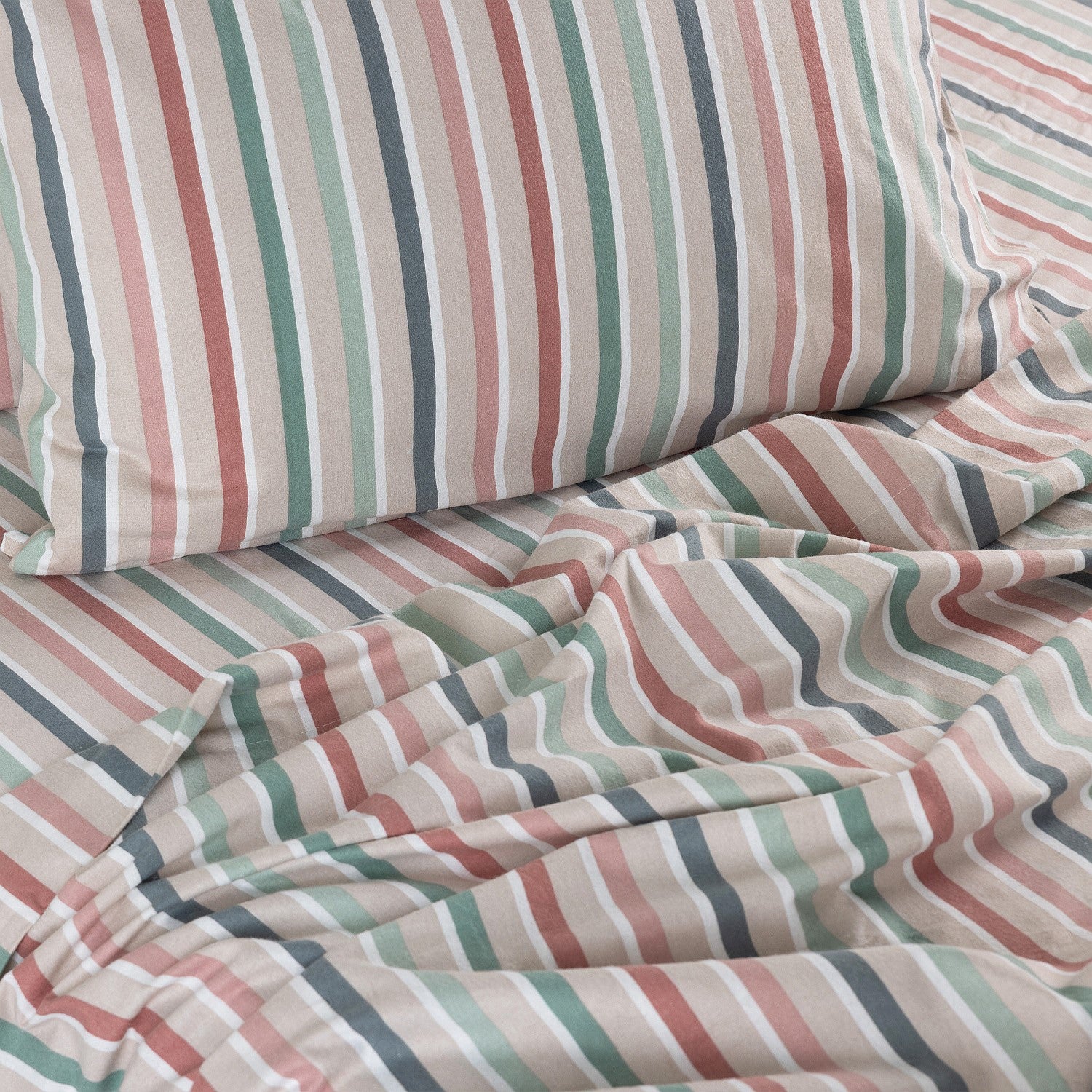 Striped bedding with pink, green, and blue colors on a bed.