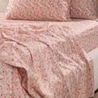 Close-up of the Marlo Mia Floral Flat Sheet draped across a bed, highlighting the detailed floral pattern and smooth cotton sateen finish.