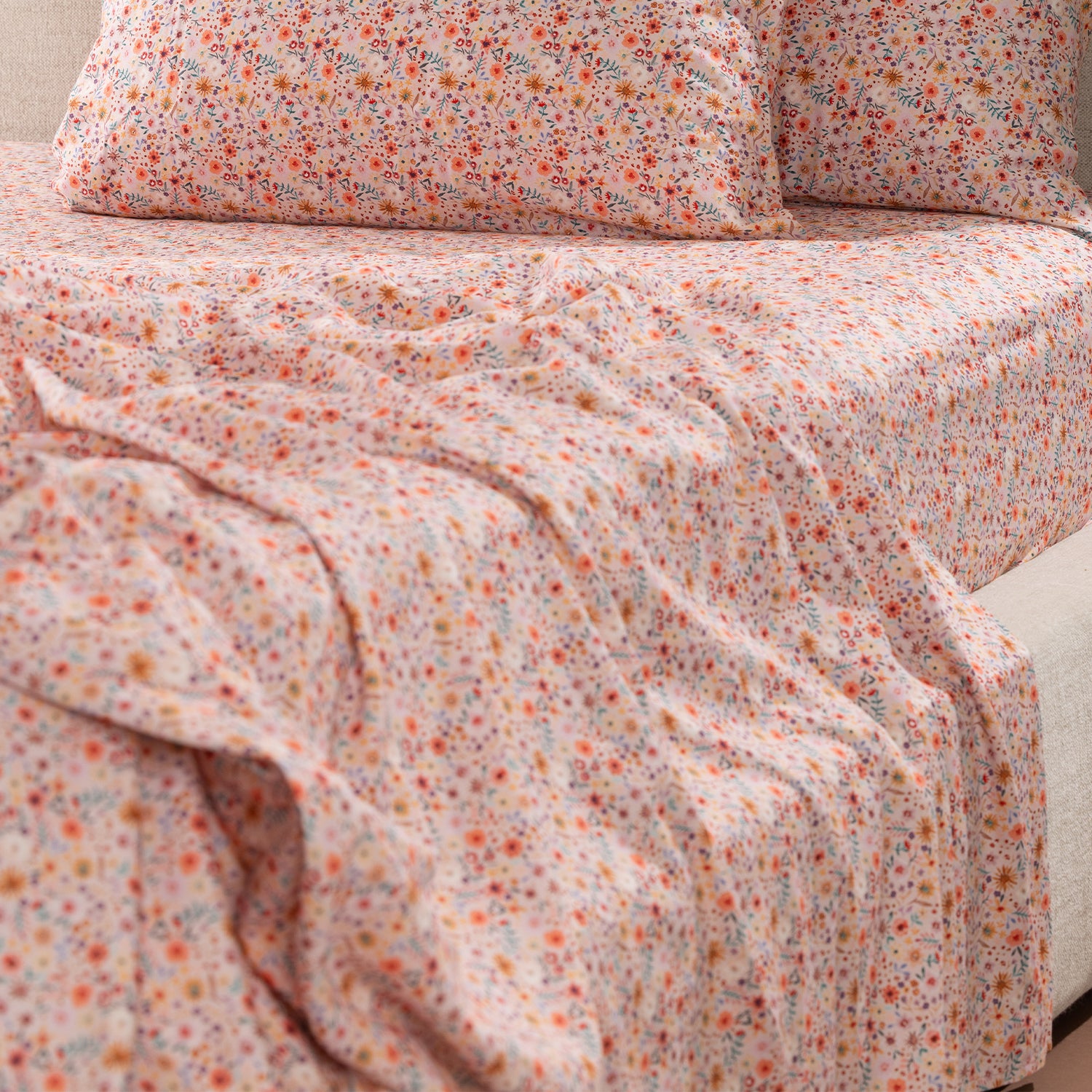 Close-up of the Marlo Mia Floral Flat Sheet draped across a bed, highlighting the detailed floral pattern and smooth cotton sateen finish.
