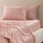 Marlo Mia Floral Flat Sheet styled on a bed with matching floral pillowcases, featuring a delicate all-over floral print in soft pink, coral, yellow and blue tones.