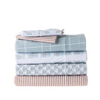 Stack of folded bed sheets with various patterns on a white background