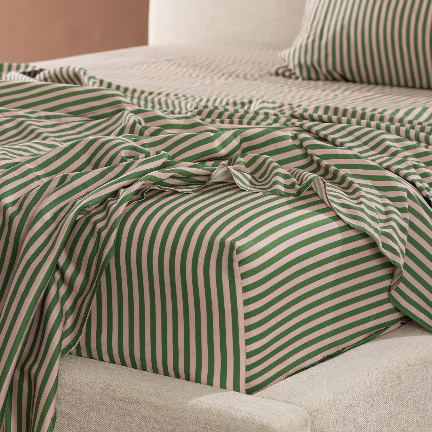 Close-up of the Marlo Mia Stripe fitted sheet highlighting the green and blush stripe design and smooth cotton sateen finish.