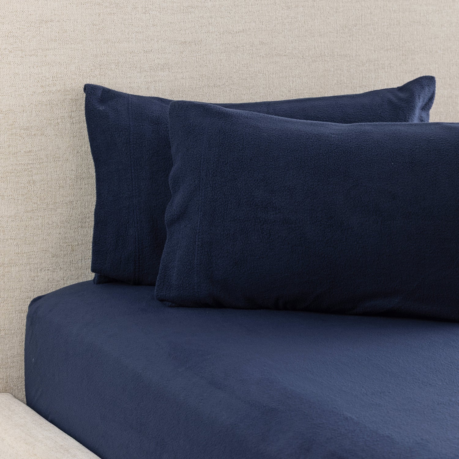 A navy polar fleece fitted sheet and matching pillowcases create a cosy, coordinated bedding look with an ultra-soft finish perfect for cooler nights.