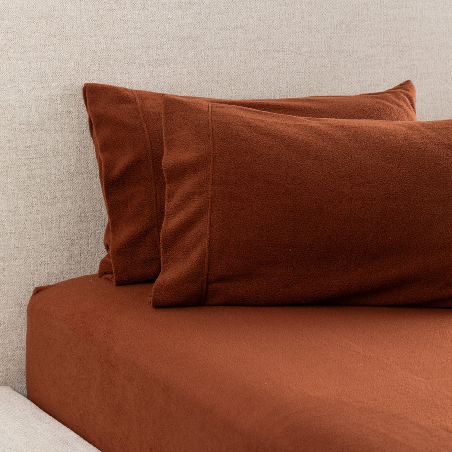A rust polar fleece fitted sheet and matching pillowcases create a cosy, coordinated bedding look with an ultra-soft finish perfect for cooler nights.