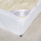 Woolrest 600gsm reversible New Zealand wool underlay close-up showing soft wool pile and fitted corner detail on a mattress.