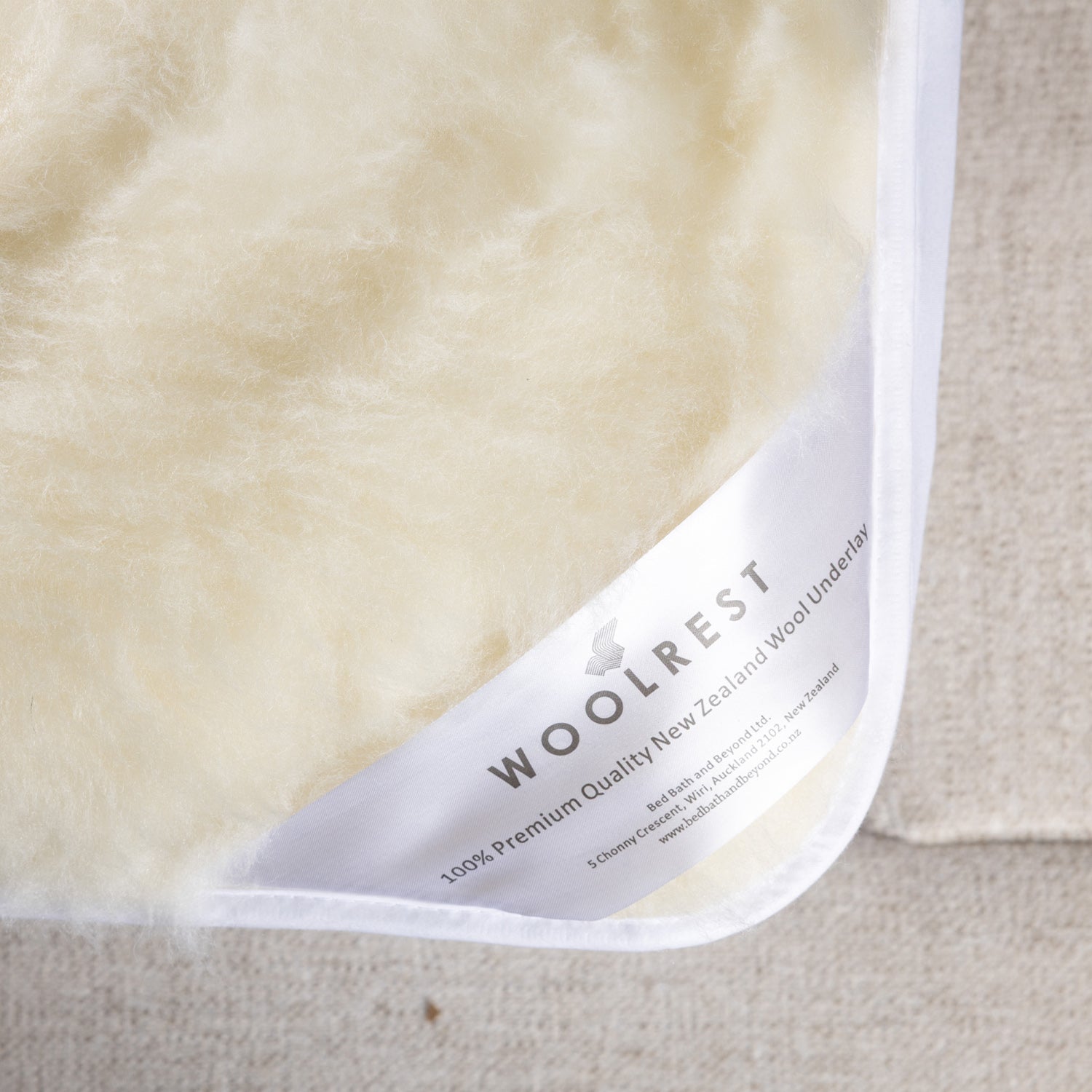 Woolrest 600gsm reversible New Zealand wool underlay close-up showing soft wool pile and fitted corner detail on a mattress.