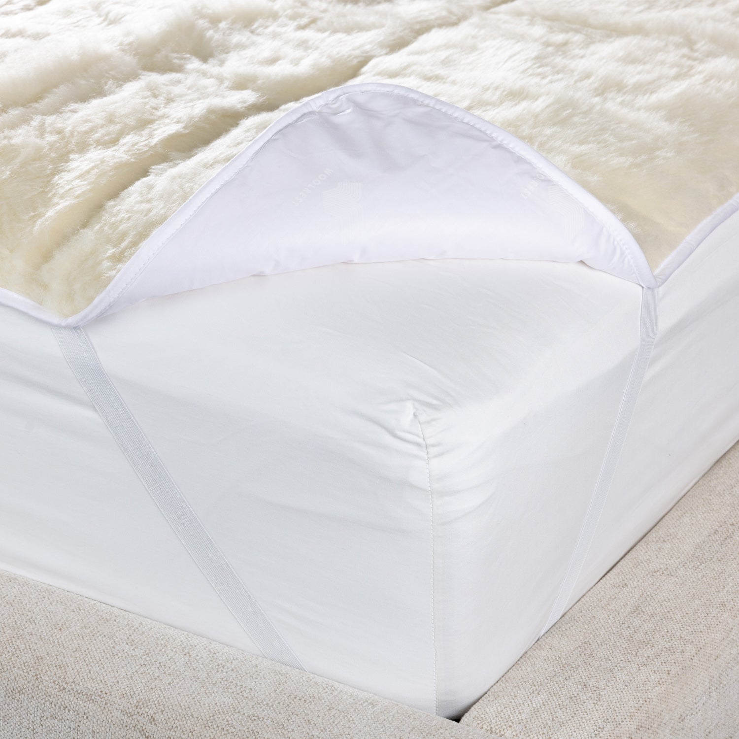 Woolrest 600gsm reversible New Zealand wool underlay close-up showing soft wool pile and fitted corner detail on a mattress.